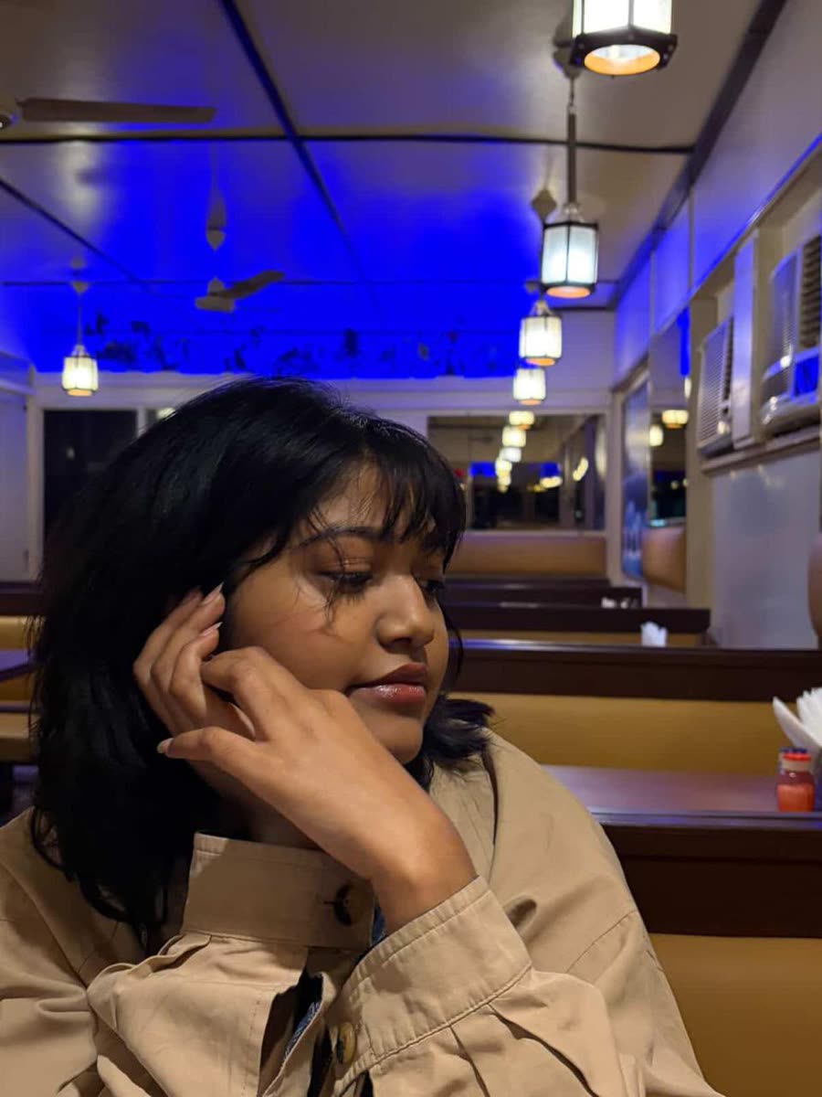 Anamika at a diner under blue ceiling lights