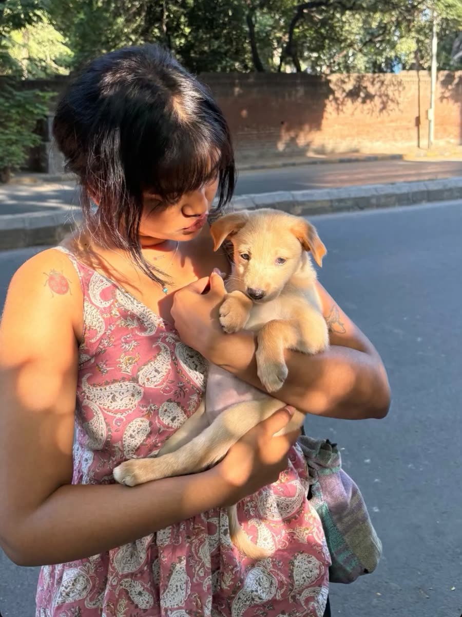 Anamika kissing a tiny puppy on the street