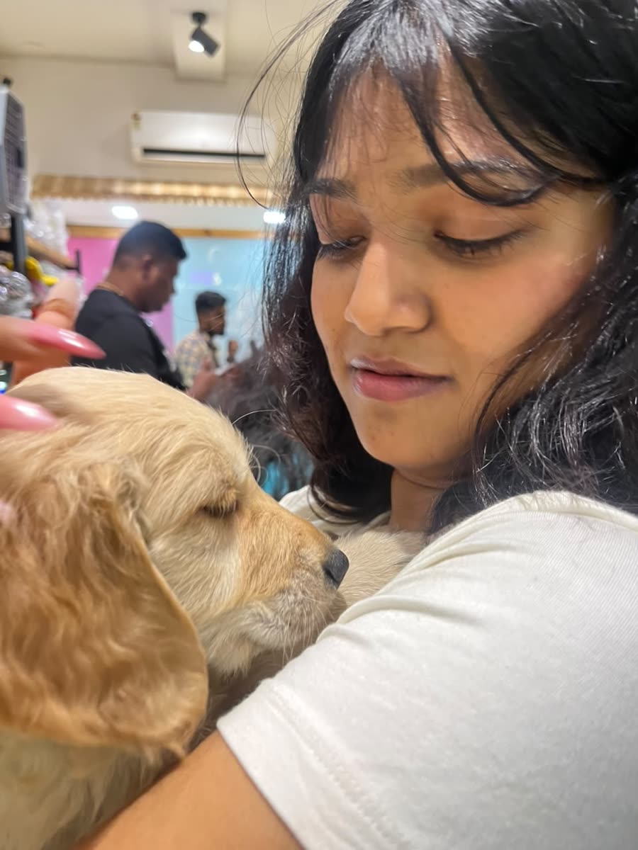 Anamika cuddling a sleepy golden puppy